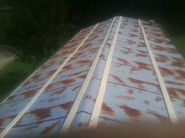 Rusted metal roof panels with new wood purlins before replacement — Storm Damage Roof Repair in Orviston by Roofing Brothers