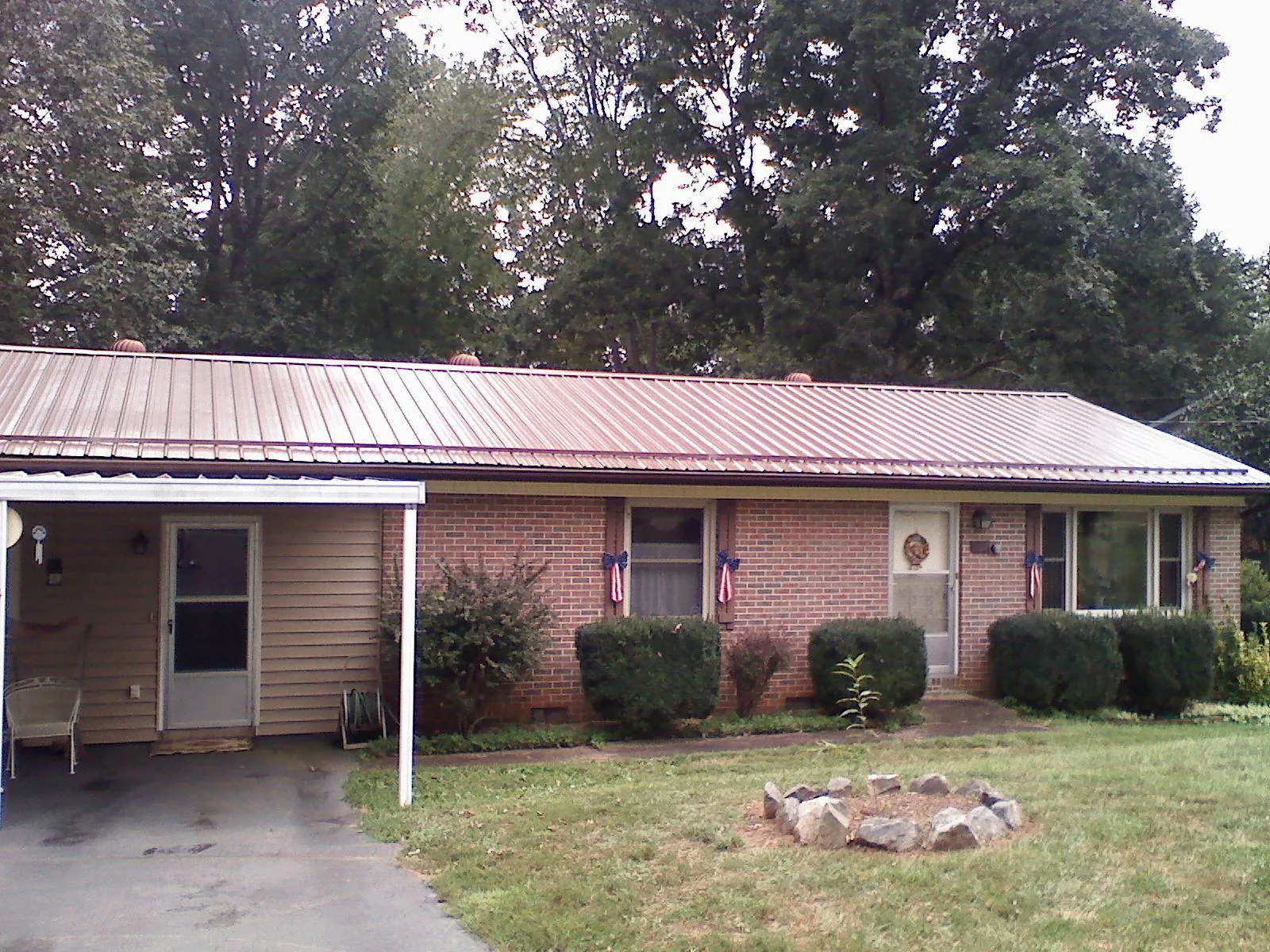 Bronze metal roof and carport on a brick ranch home — Roof Repair work by our crew in Orviston